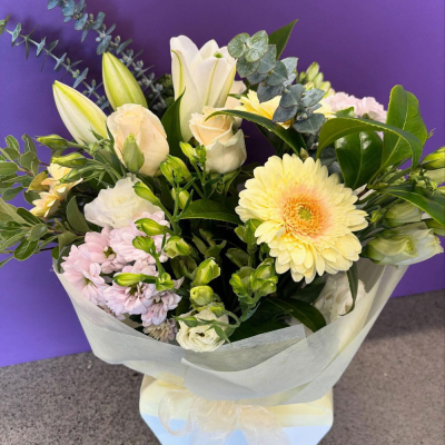 Soft Serenity Bouquet - A gentle bouquet in cream, buttery yellow and soft pink with a lemon gerbera, roses, lily buds and pastel stock wrapped in ivory tissue. Delicate and calming — a beautiful choice for sympathy or a gentle pick-me-up.